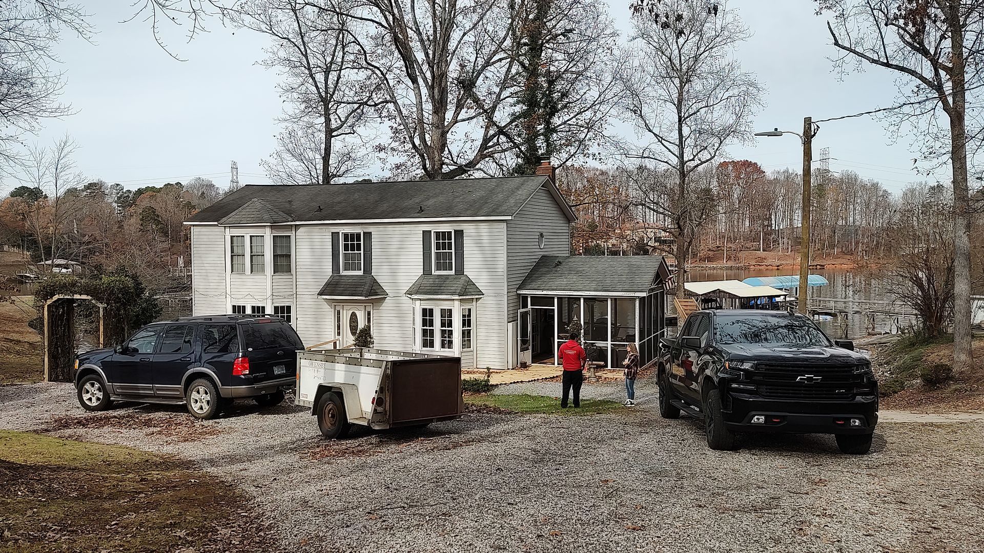 A couple of cars are parked in front of a house.