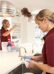 Two woman cleaning the kitchen area