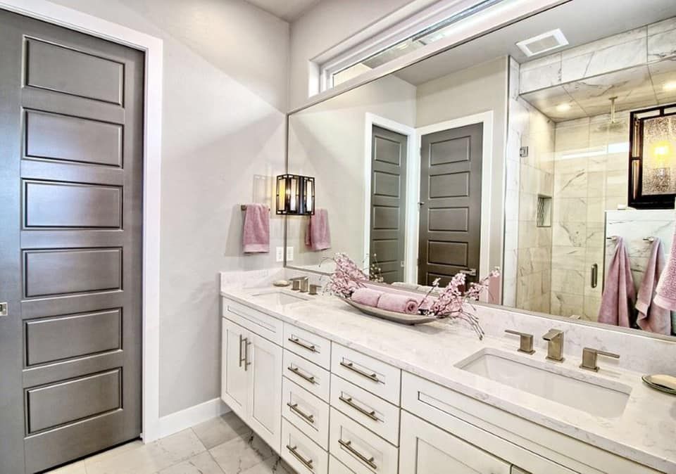 A bathroom with two sinks and a large mirror.