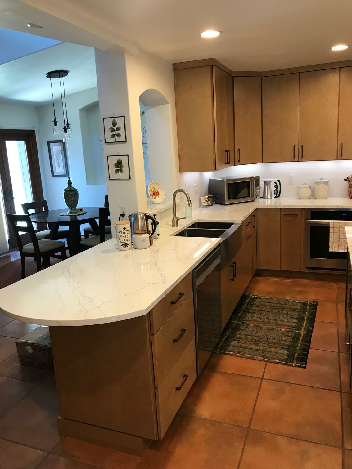 A kitchen with wooden cabinets and white counter tops