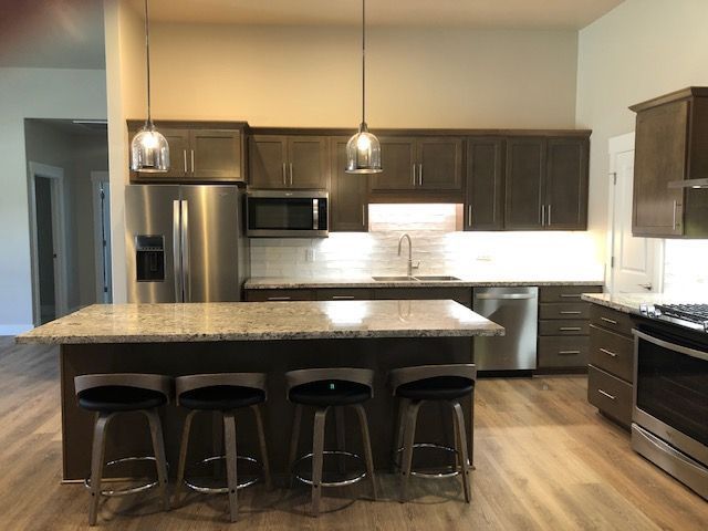 A kitchen with stainless steel appliances and a large island - before photo