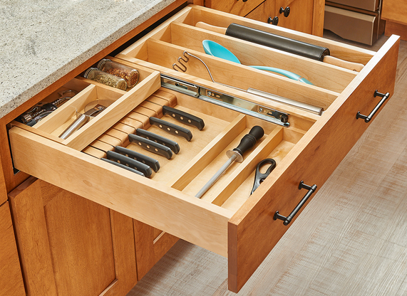 A kitchen drawer with knives and utensils in it