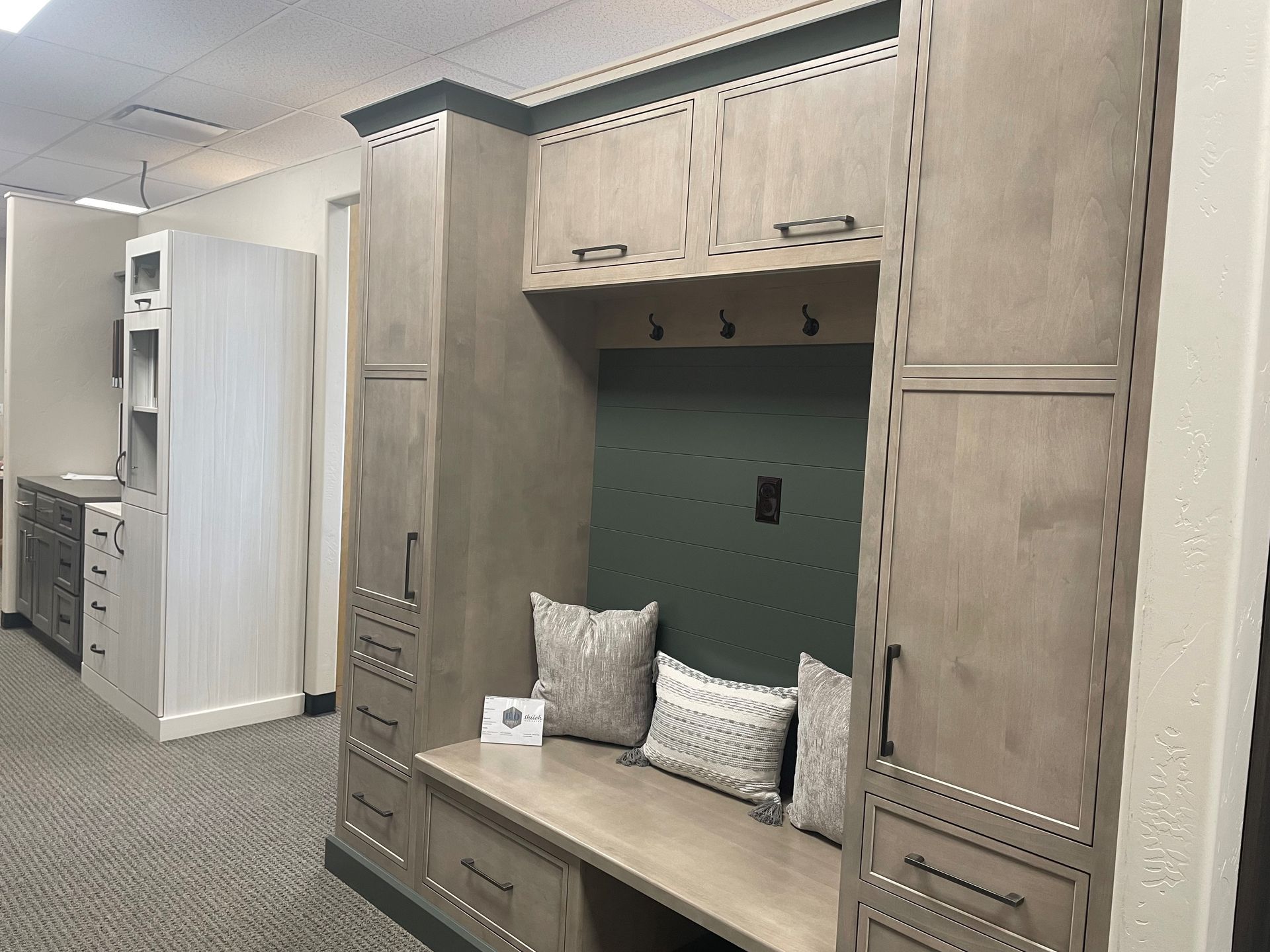 A room with a bench and lots of cabinets and drawers