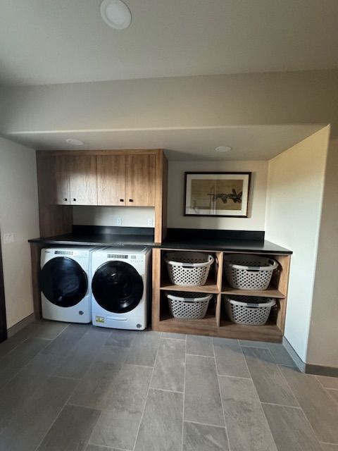 A laundry room with a washer and dryer and baskets