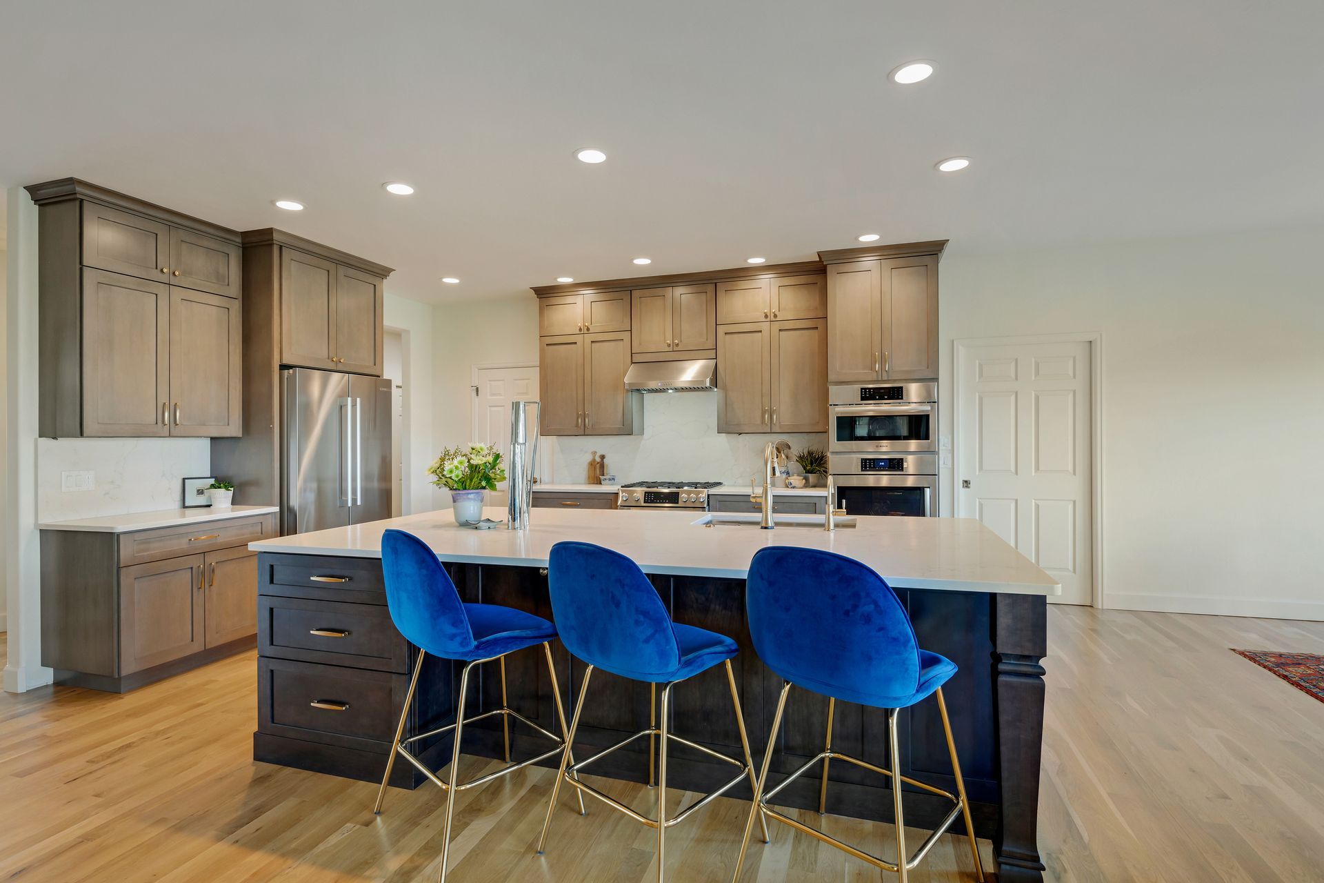 A kitchen with a large island and blue chairs