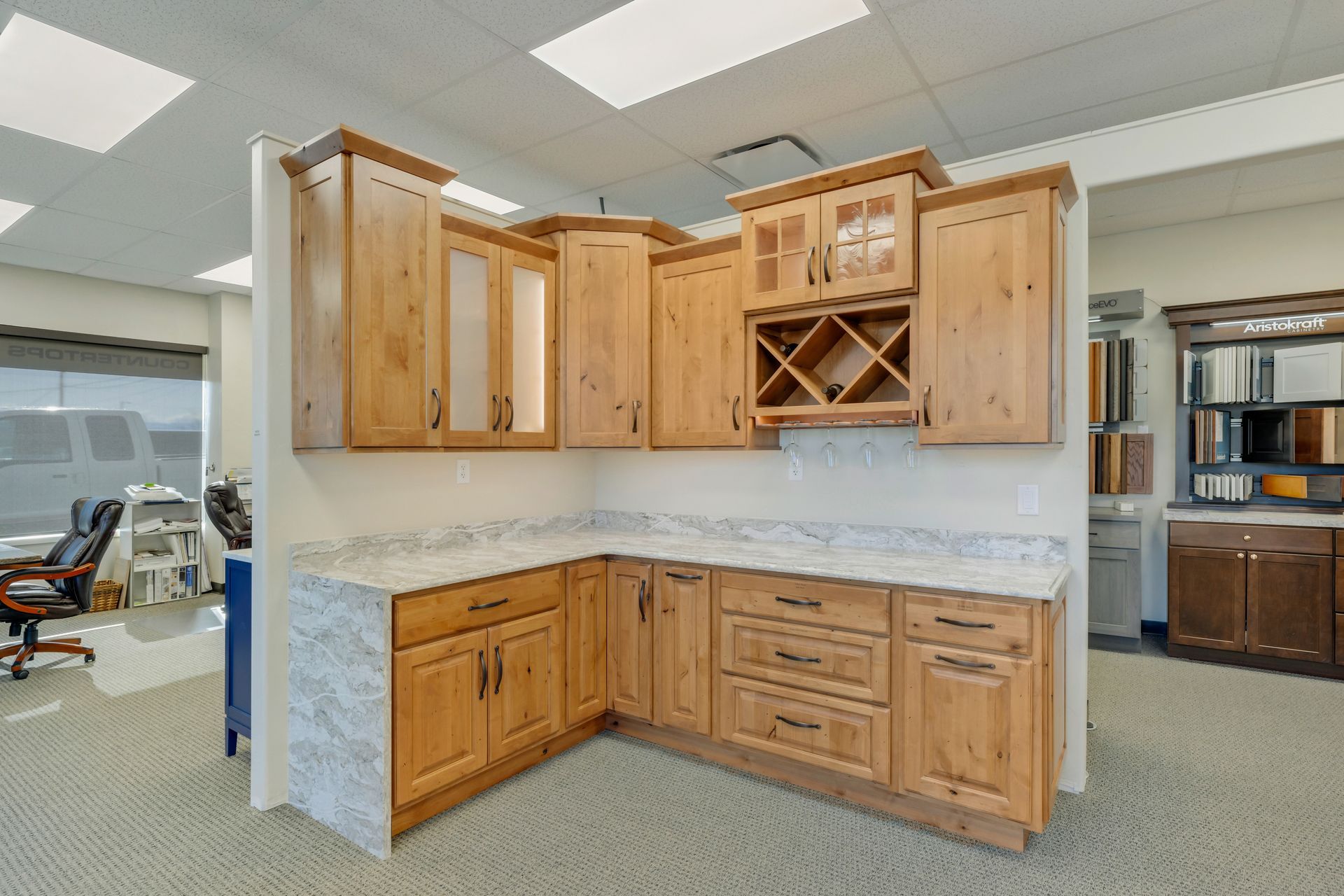 a kitchen with wooden cabinets and marble counter tops in a showroom .
