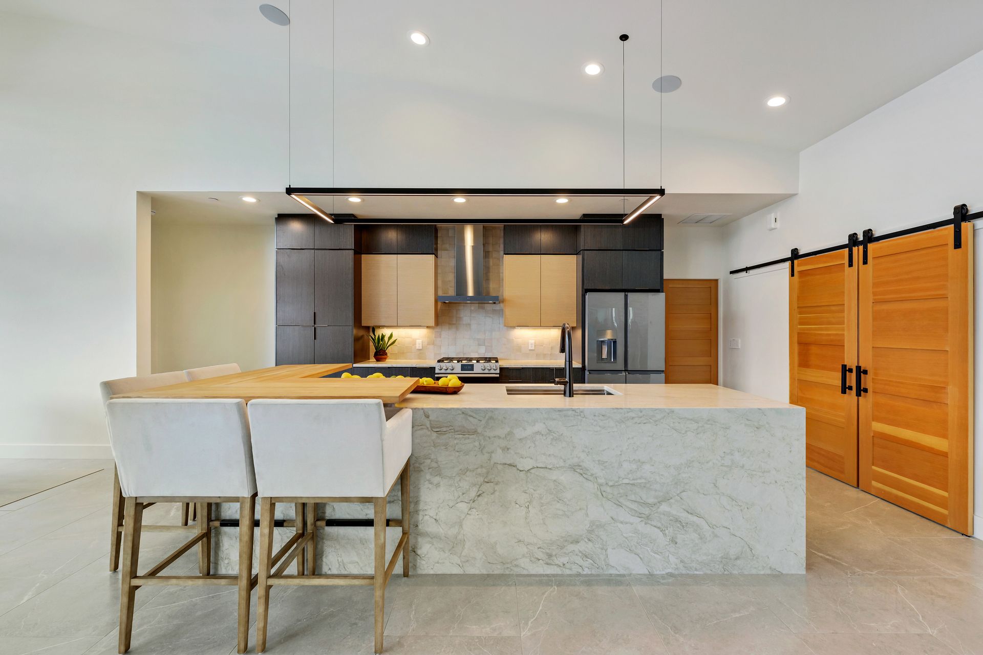 a kitchen with a large island and sliding barn doors