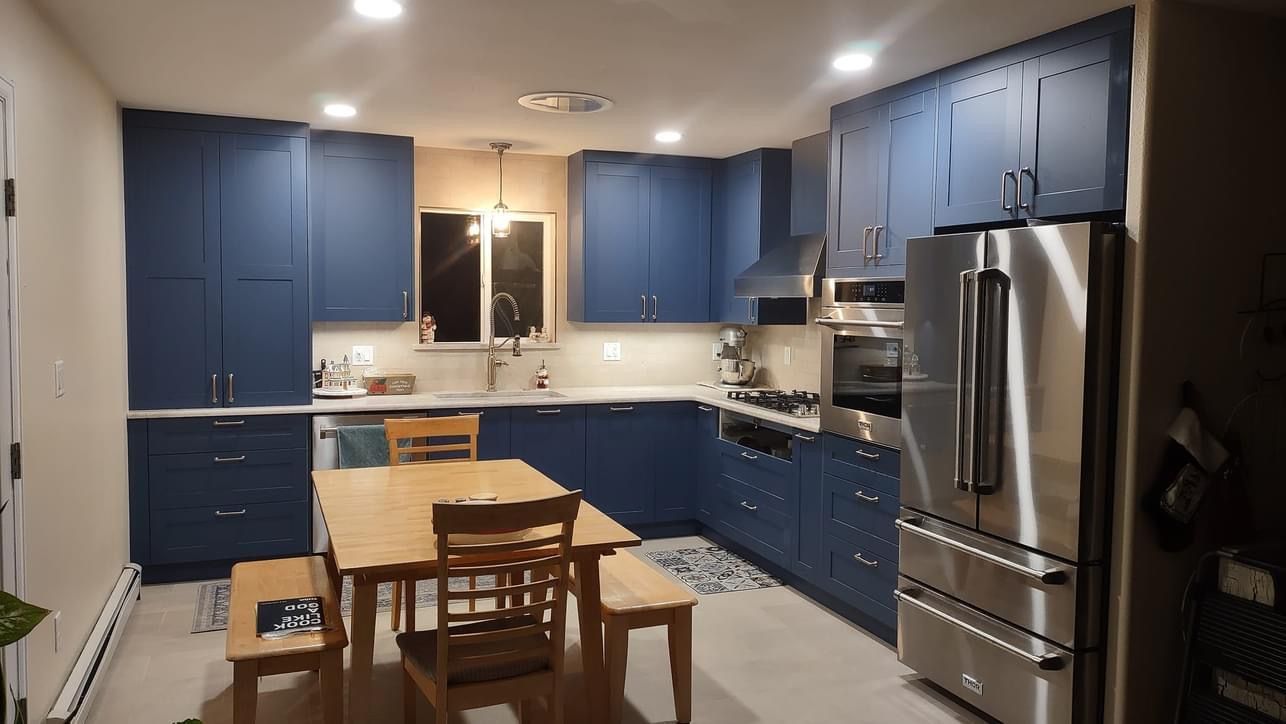 A kitchen with blue cabinets and stainless steel appliances