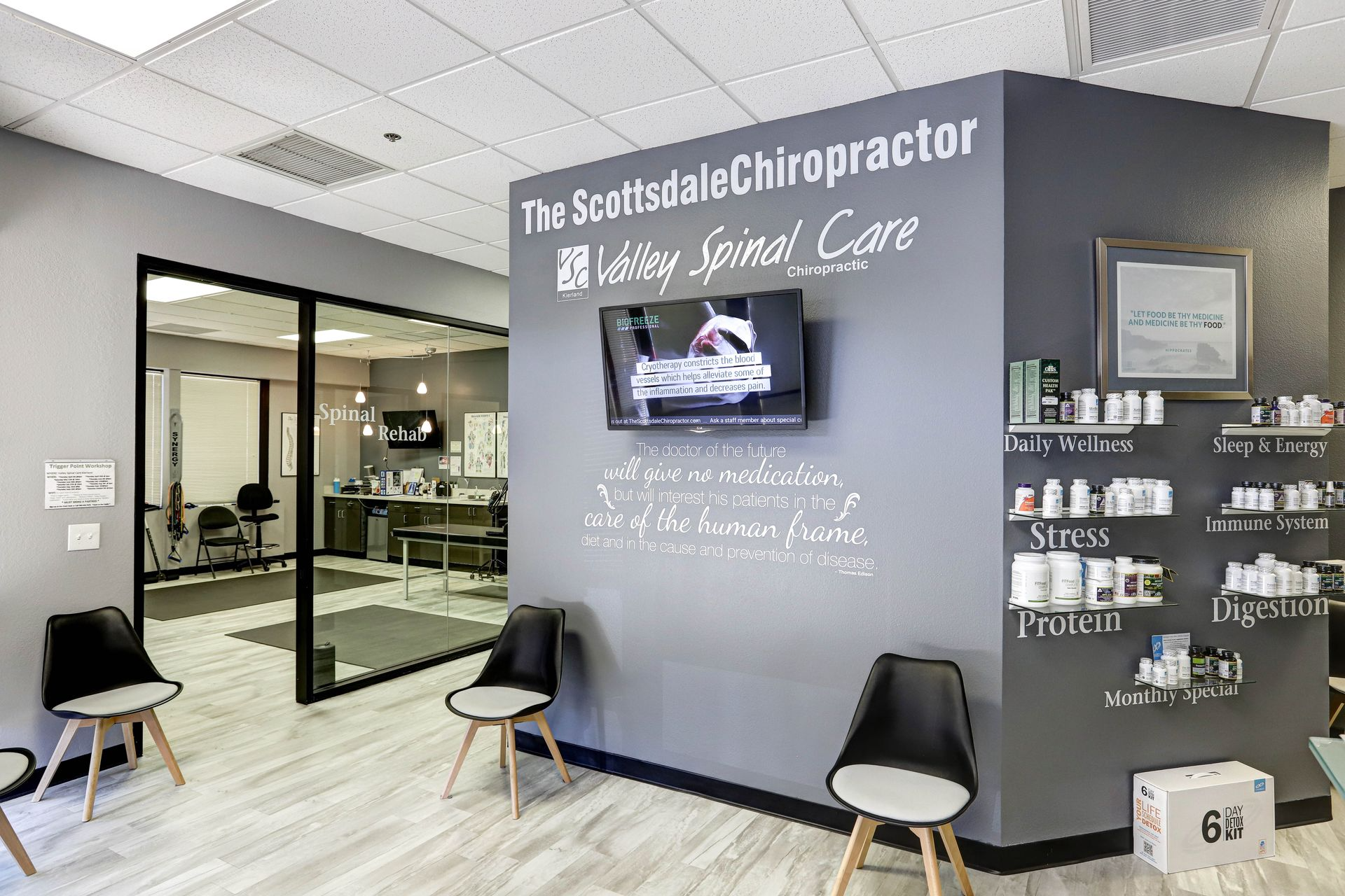 Waiting area of a chiropractic office with chairs, a TV, and shelves displaying supplements.