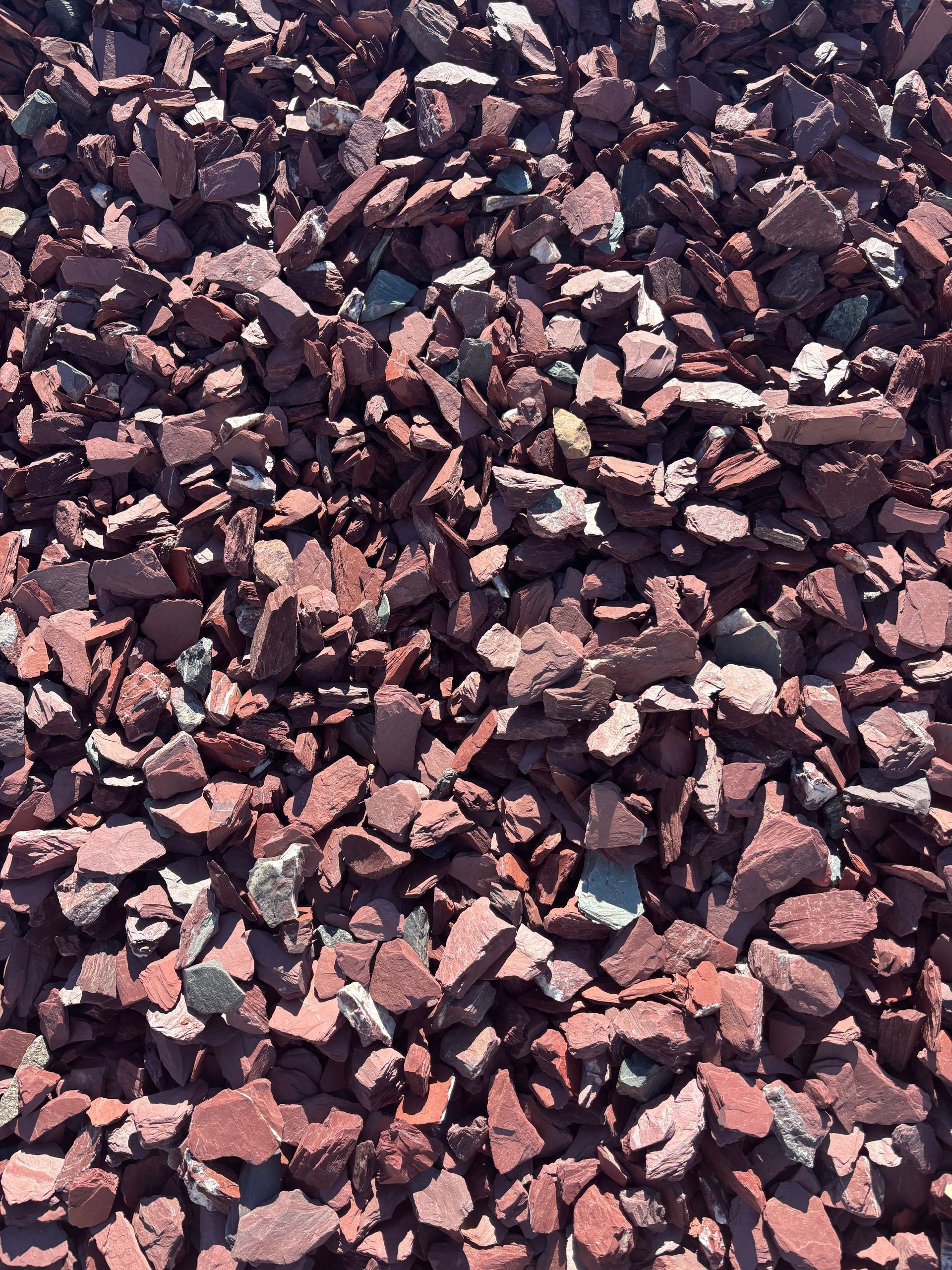 Close-up of a pile of small dark and pinkish gravel stones