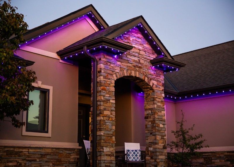 The front of a house with purple lights on it.