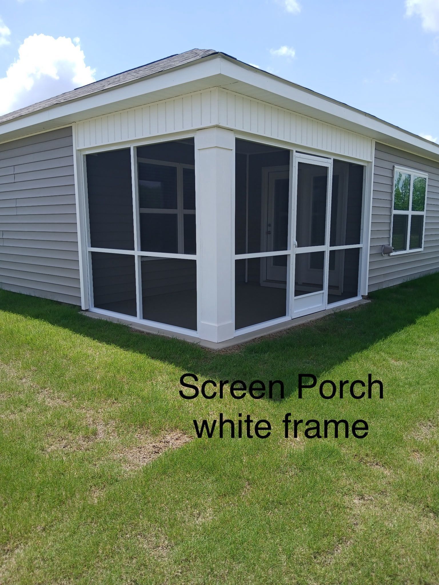 Screen porch with white frame and black mesh panels on a house exterior.