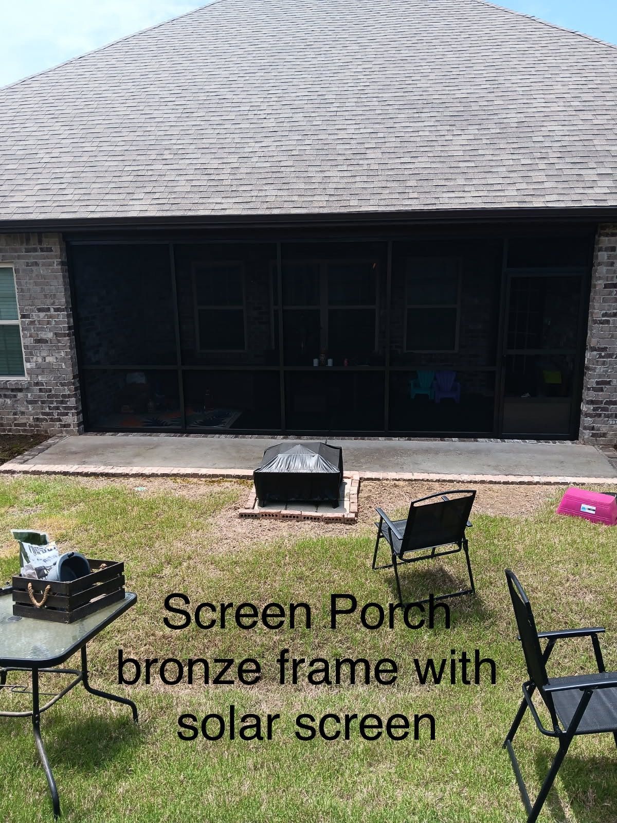 Back porch with bronze-framed solar screen doors, patio furniture, and a grassy yard