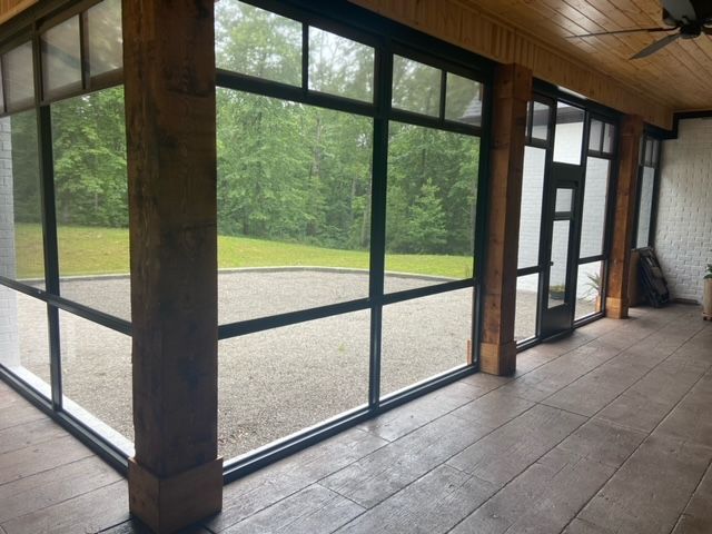 Sunroom with wood ceiling, tiled floor, and large floor-to-ceiling windows overlooking a green lawn