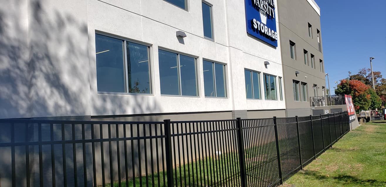 Exterior view of a white and gray building with a black fence.