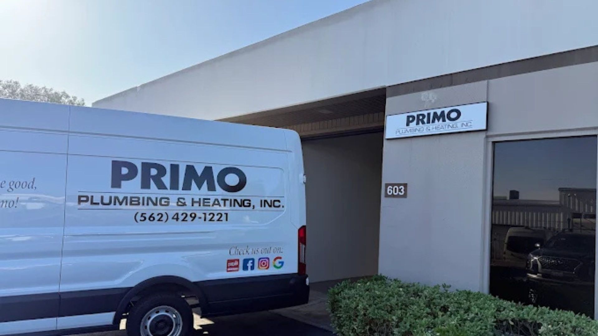 Primo Plumbing & Heating van parked outside business entrance.