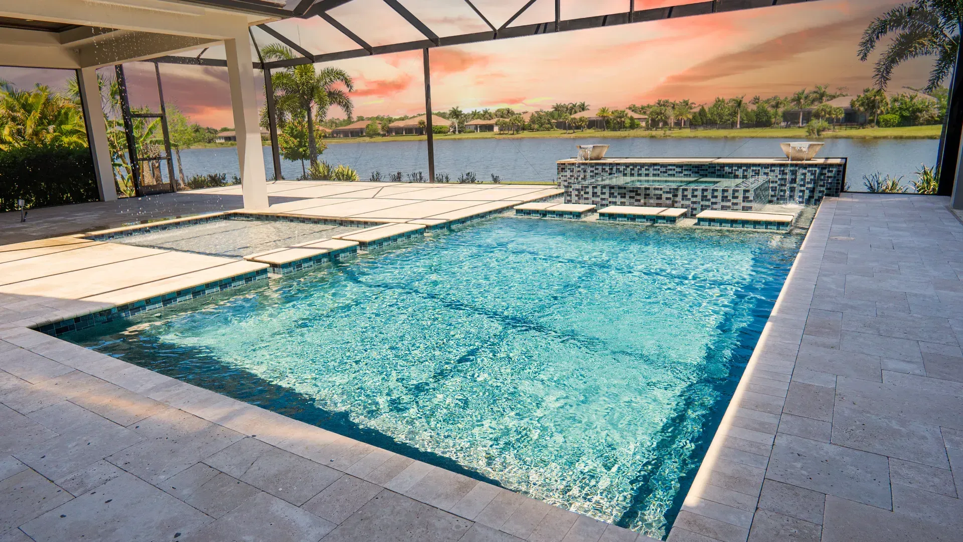 Covered pool patio overlooking calm waterfront at sunset