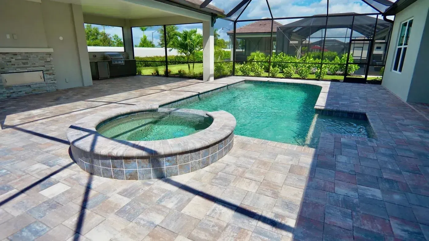 Screened-in backyard patio with a turquoise pool and round spa under a covered lanai.