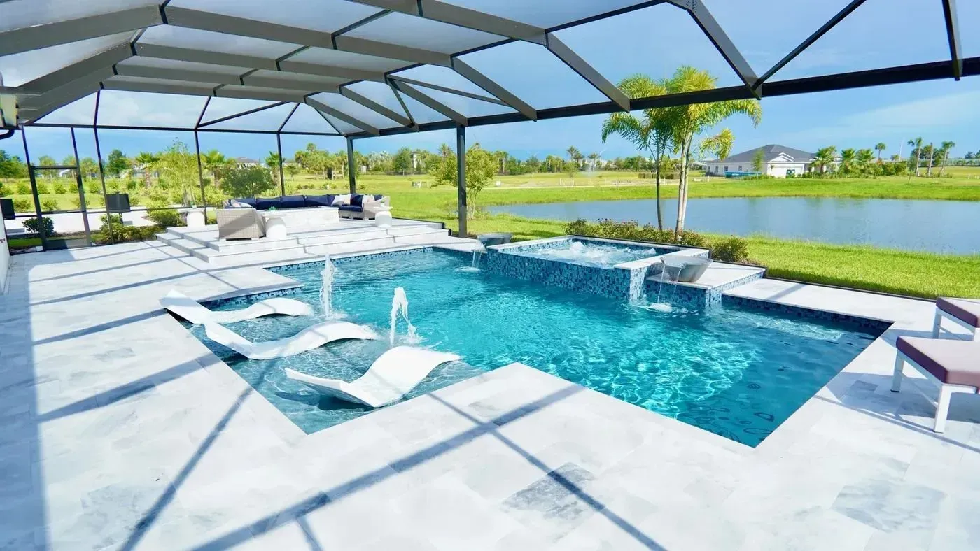 Modern backyard pool with white loungers, shaded canopy, and green lawn under a bright sky