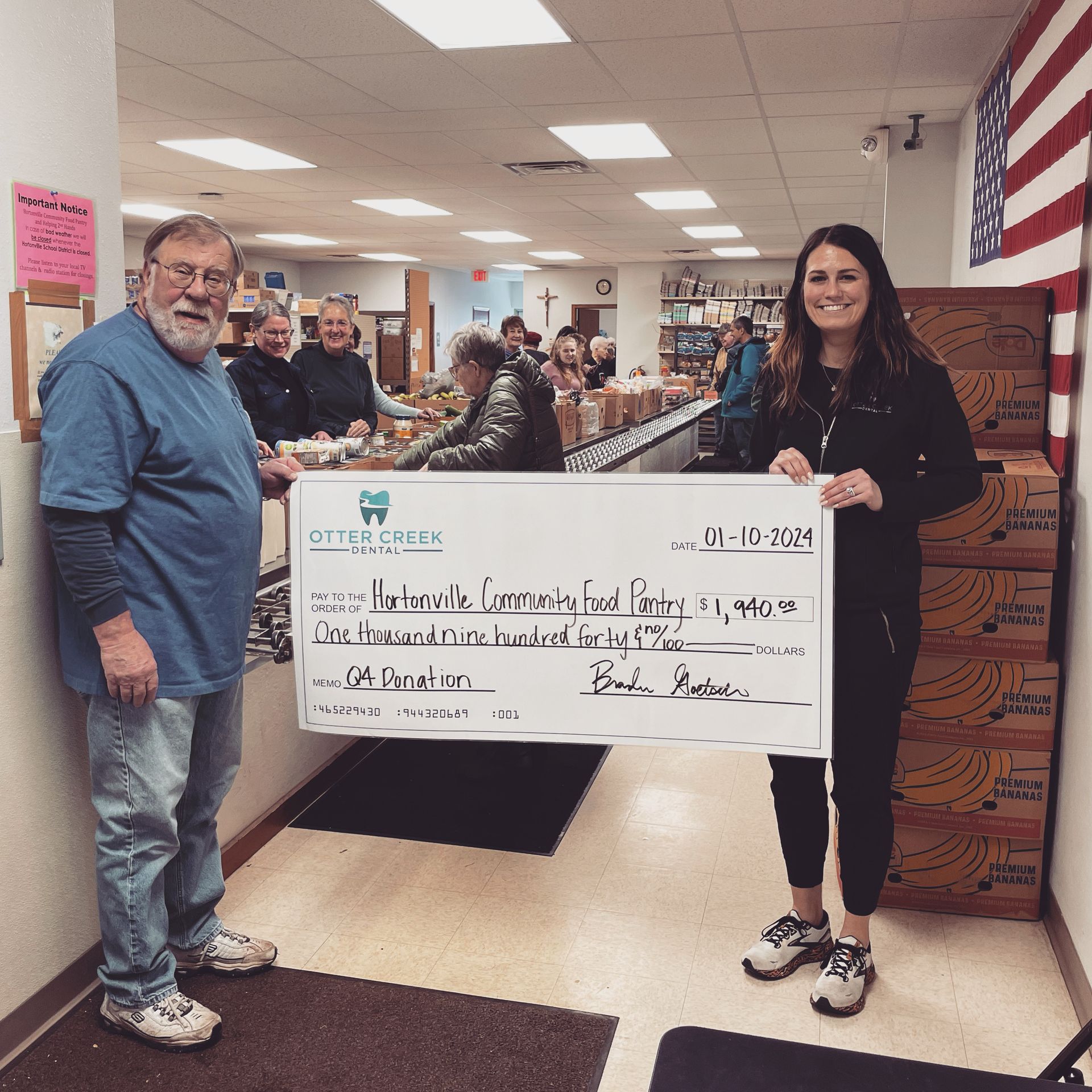 Two people holding a large check.