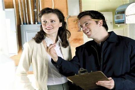 A man is holding a clipboard and talking to a woman.