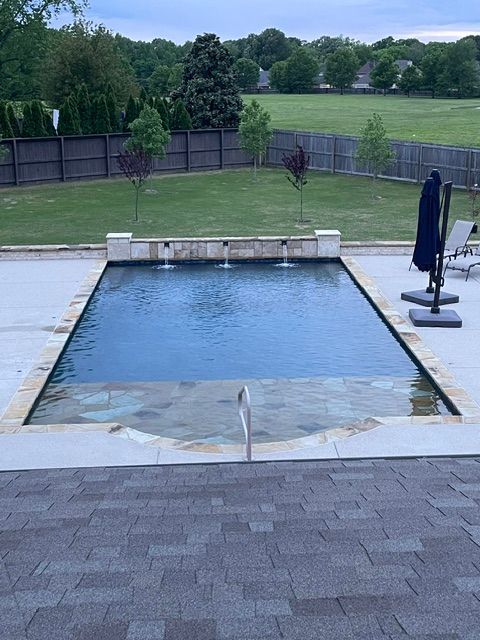 A large swimming pool is sitting on top of a brick patio.