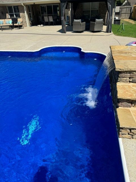 A swimming pool with a waterfall coming out of it