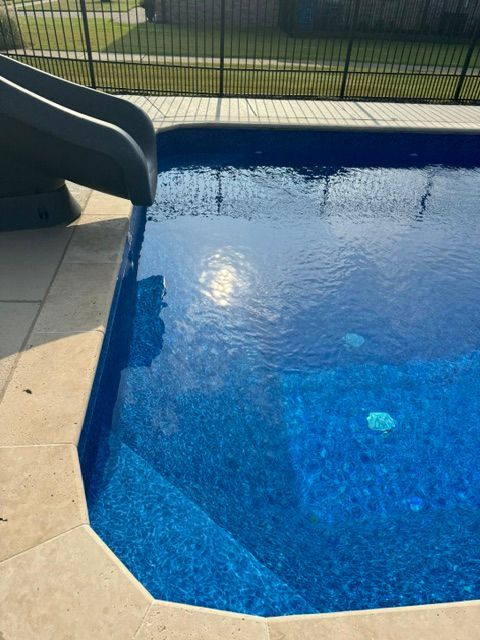 A swimming pool with a slide in the background