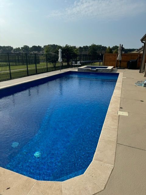 A good-looking large blue swimming pool with a fence around it