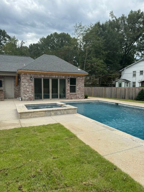 A house with a large swimming pool in front of it