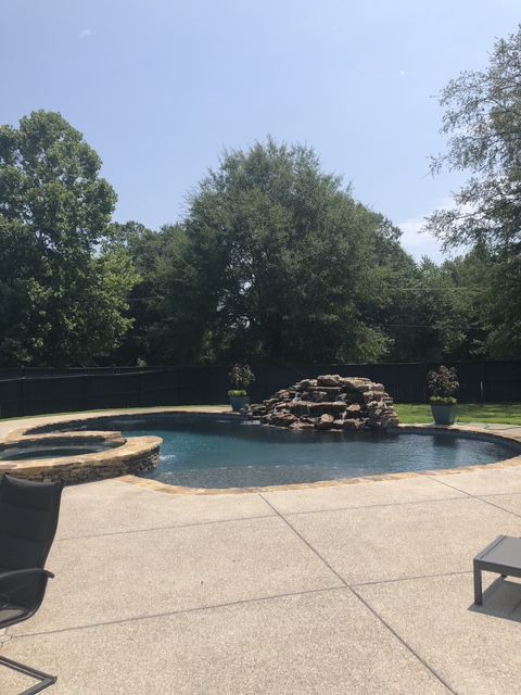 A large swimming pool with a waterfall in the middle