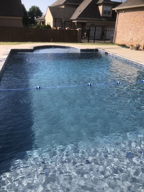 A large swimming pool in the backyard of a house.