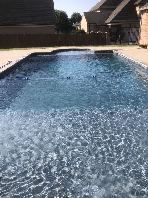 A good-looking large swimming pool in the backyard of a house.
