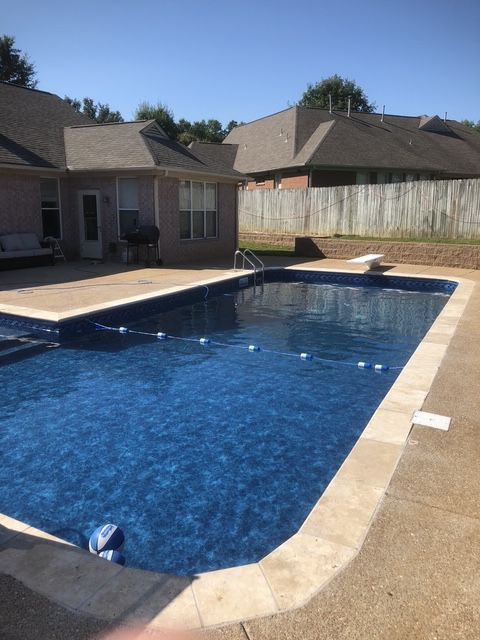 A large blue swimming pool in front of a house
