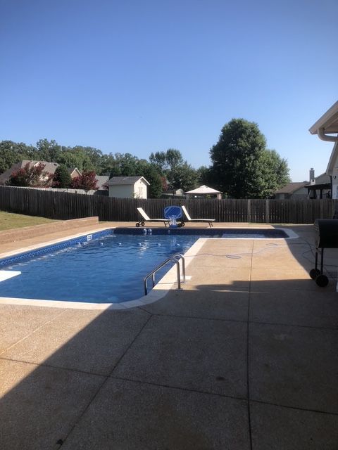 A large swimming pool in the backyard of a house