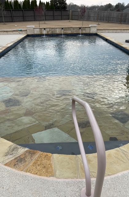 A large swimming pool with a staircase leading to it.