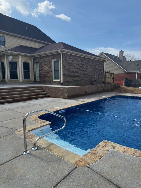 A large swimming pool in front of a house