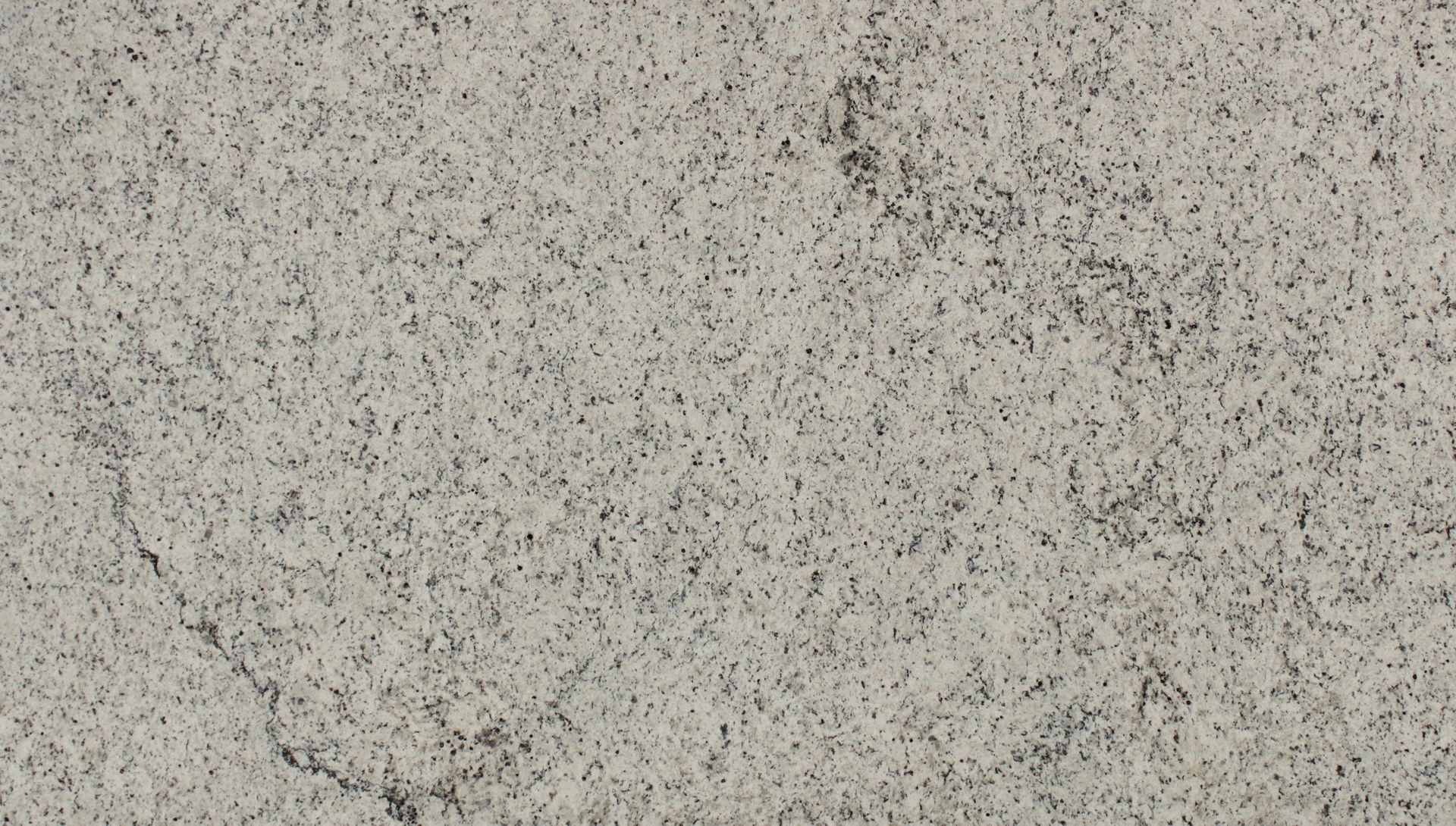 Speckled light gray stone or concrete surface with subtle dark flecks and a faint crack line
