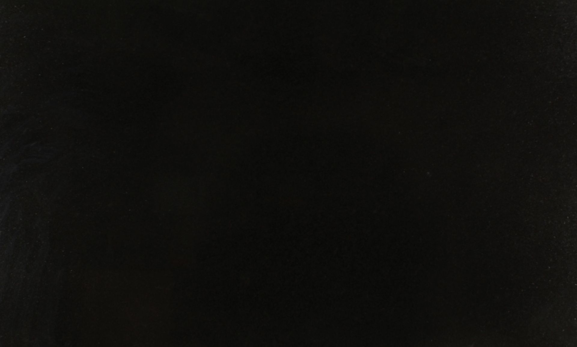 Mostly black, dim image with faint greenish highlights in the lower left and center.