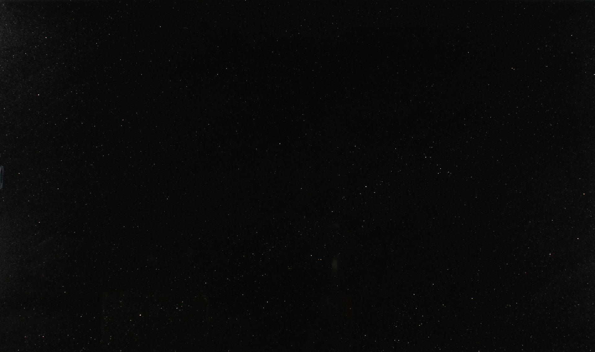 Dark starry night sky with faint scattered stars and black background
