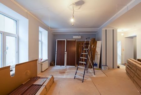 Renovated room with ladders, stacked wood, and unfinished walls and ceiling.