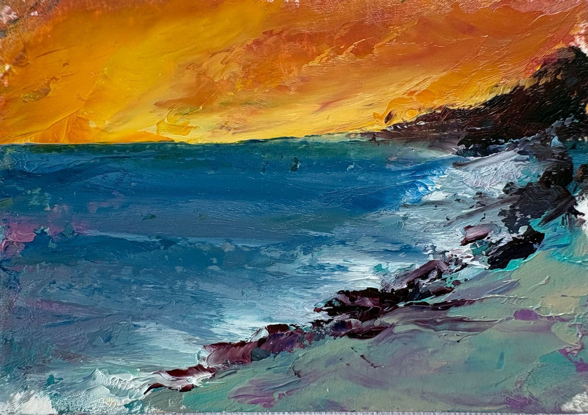 An oil painting of a vibrant sunset over a deep blue ocean, with waves crashing against a rocky, colorful shoreline.