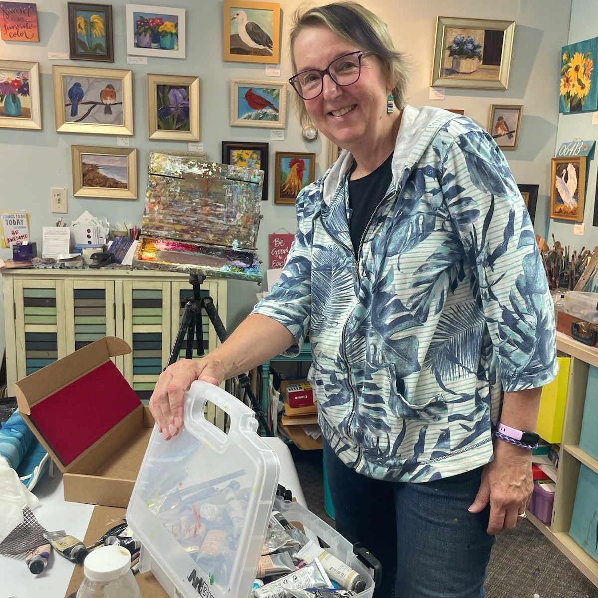 A woman is standing in a room with paintings on the wall