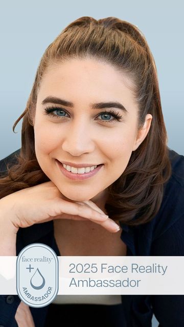 A woman is smiling with her hand on her chin.