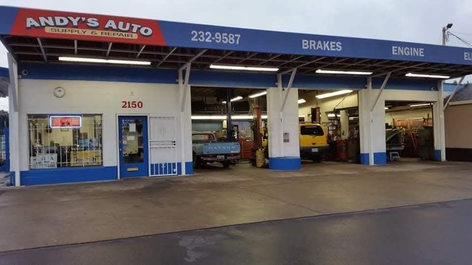 Andy's Auto Supply and Repair shop, featuring a blue and white building with three service bays and vehicles inside.