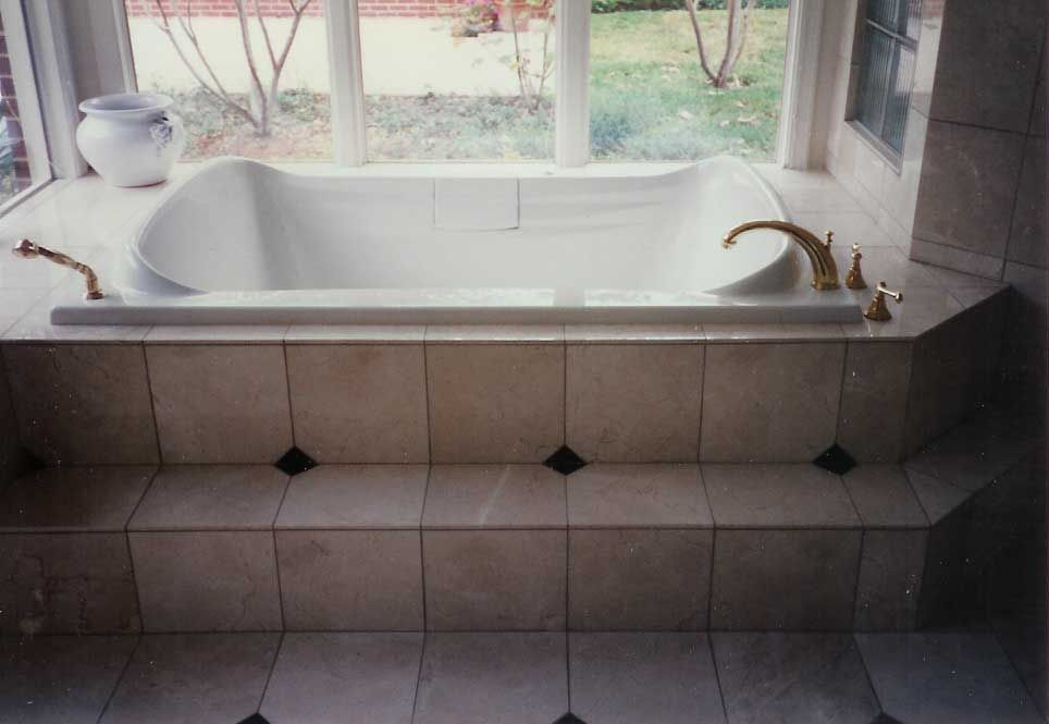A bathtub in a bathroom next to a window
