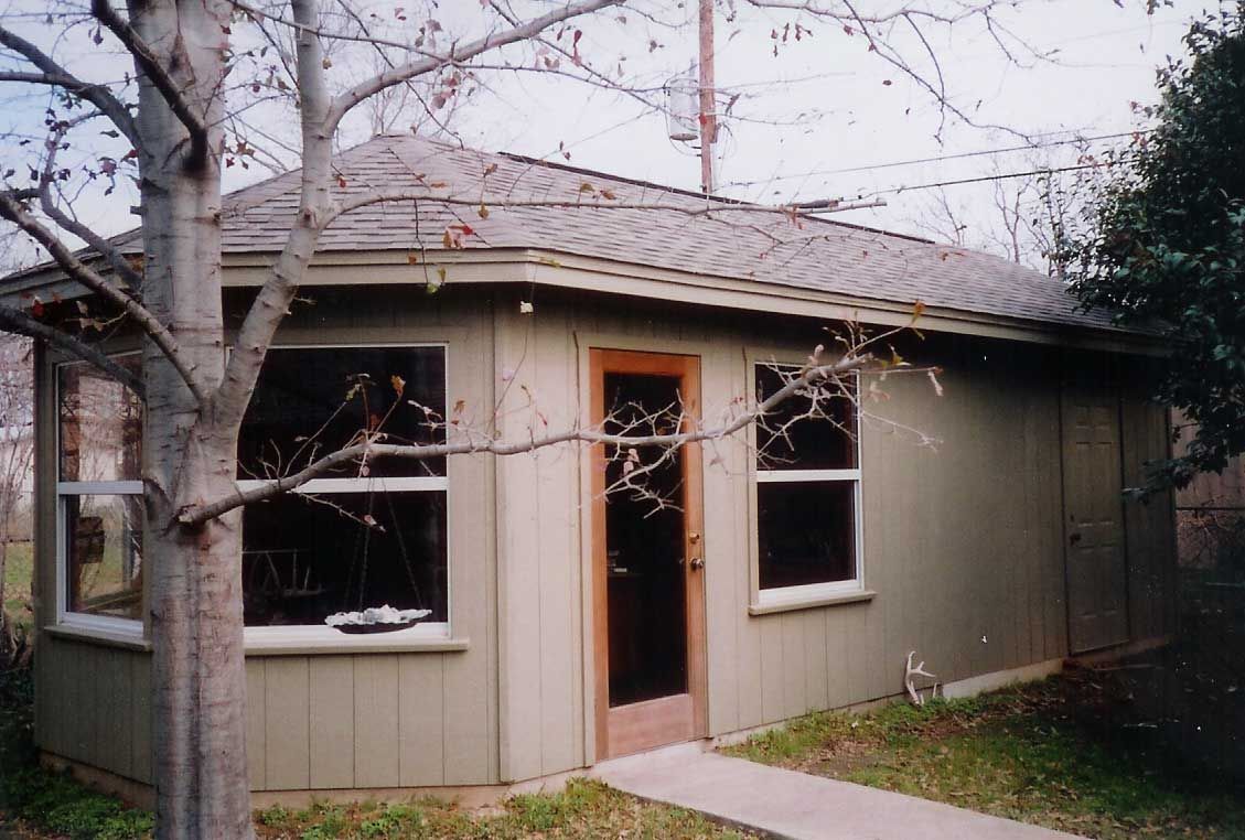 A small house with a tree in front of it