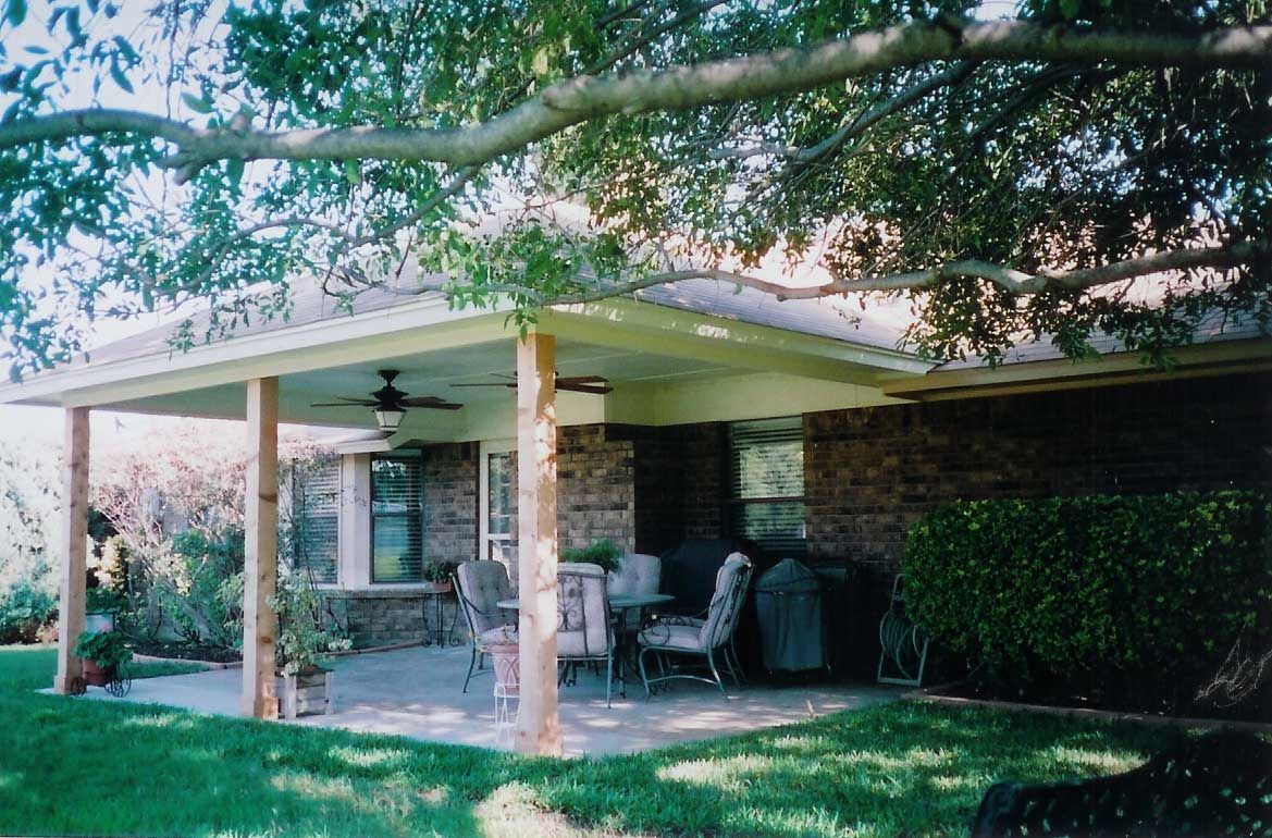 A brick house with a covered patio and a ceiling fan