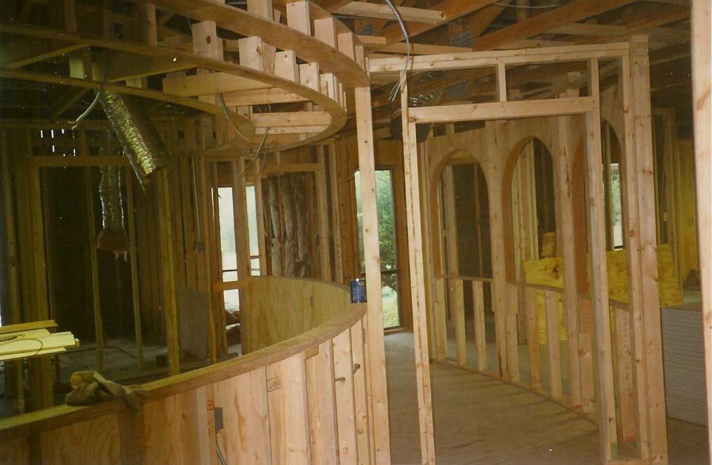A house is being built with wooden frames and a curved wall.