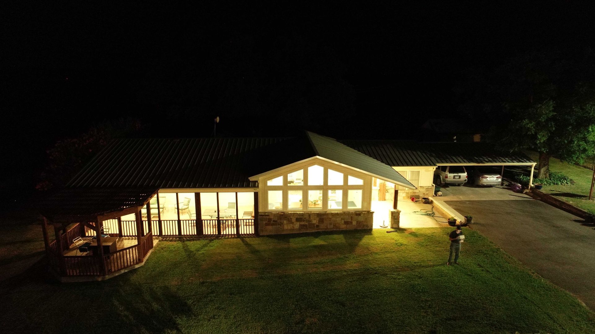 An aerial view of a house lit up at night.